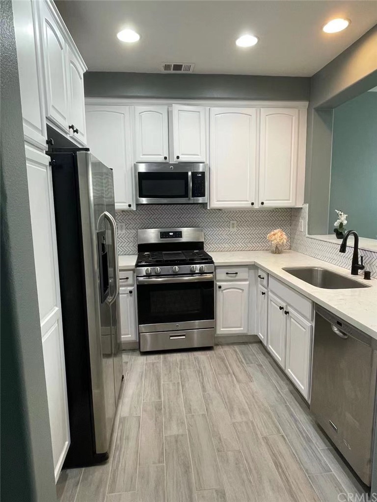 21 Thorp Ladera Ranch Ladera Ranch, CA 92694 - Photo 13 of 15 a kitchen with white cabinets stainless steel appliances and a sink
