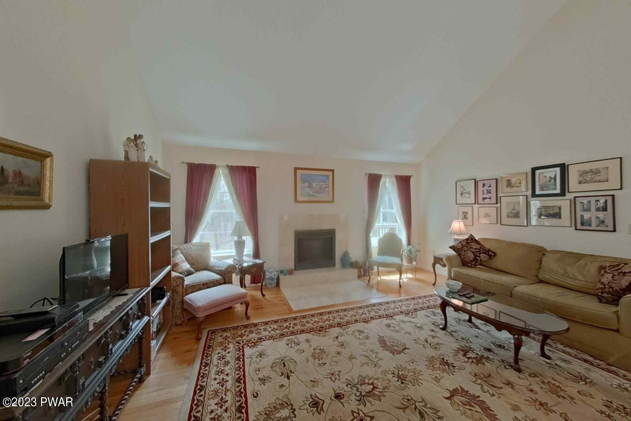131 Maple Ridge Road Milford, PA 18337 - Photo 12 of 54 a living room with furniture a flat screen tv and a fireplace