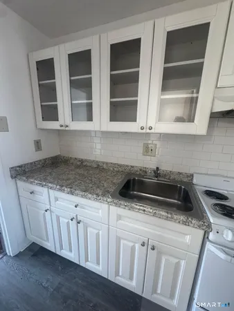 a kitchen with granite countertop a sink and a stove