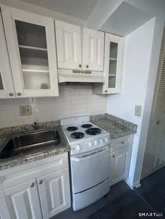 a white stove top oven sitting inside of a kitchen
