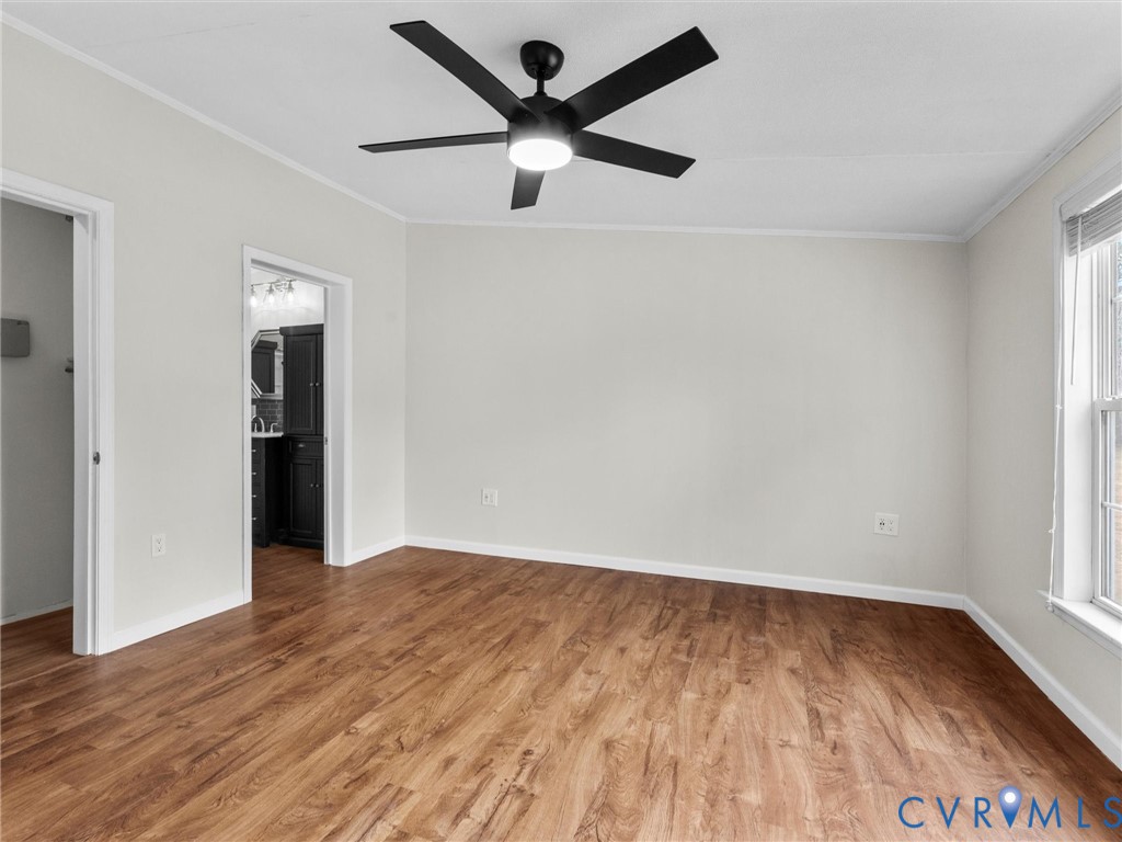 4772 Carsley Road Waverly, VA 23890 - Photo 13 of 38 an empty room with wooden floor and a ceiling fan