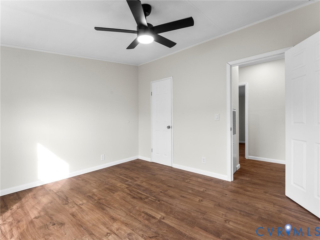 4772 Carsley Road Waverly, VA 23890 - Photo 26 of 38 an empty room with wooden floor and a ceiling fan
