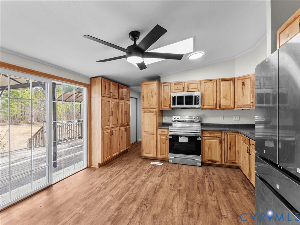 4772 Carsley Road Waverly, VA 23890 - Photo 5 of 38 a kitchen with stainless steel appliances granite countertop a refrigerator a stove top oven a sink and dishwasher with wooden floor