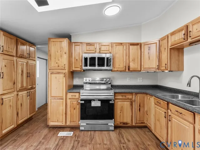 a kitchen with stainless steel appliances granite countertop a stove a sink and a refrigerator