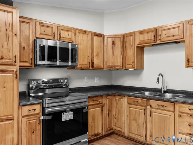 a kitchen with stainless steel appliances granite countertop a stove a sink and a microwave