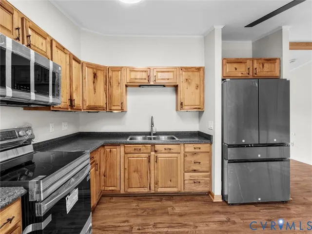 a kitchen with stainless steel appliances granite countertop a refrigerator a stove and a sink