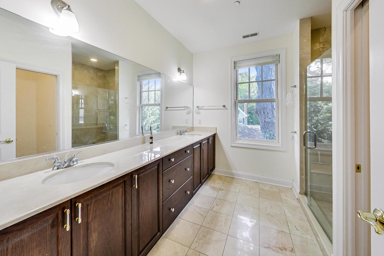720 Green Bay Road, Unit 2D Winnetka, IL 60093 - Photo 19 of 41 a spacious bathroom with a double vanity sink a mirror and a bathtub