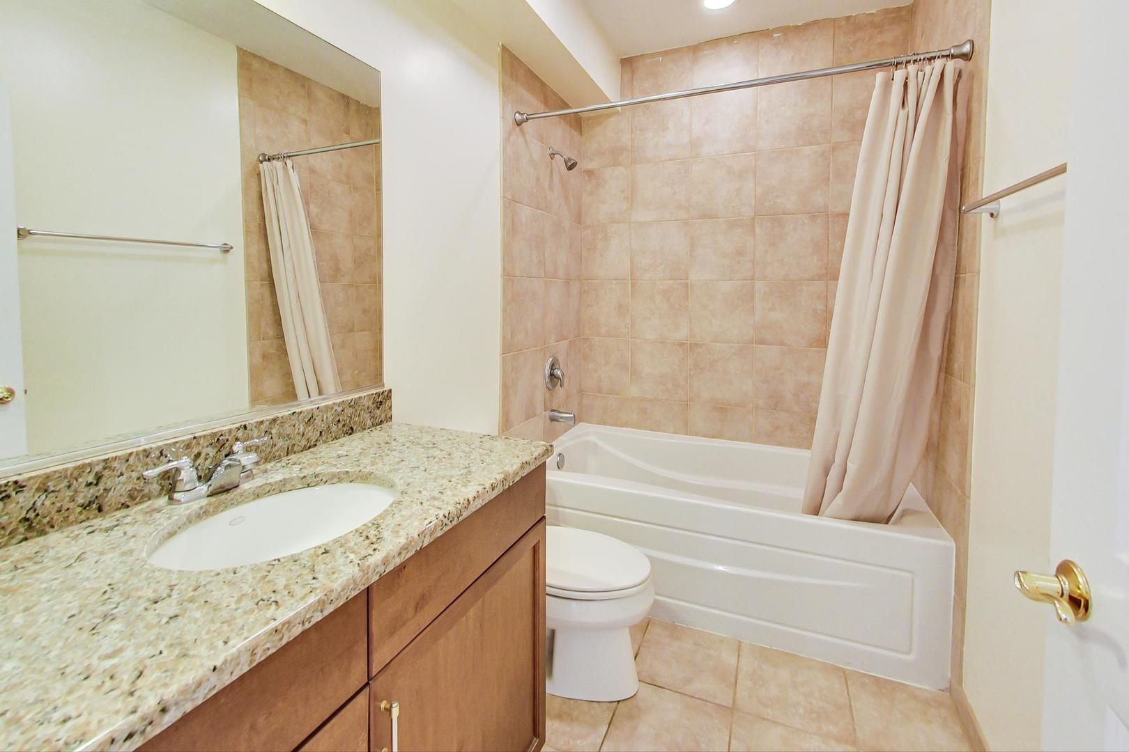 720 Green Bay Road, Unit 2D Winnetka, IL 60093 - Photo 30 of 41 a bathroom with a granite countertop sink toilet and shower