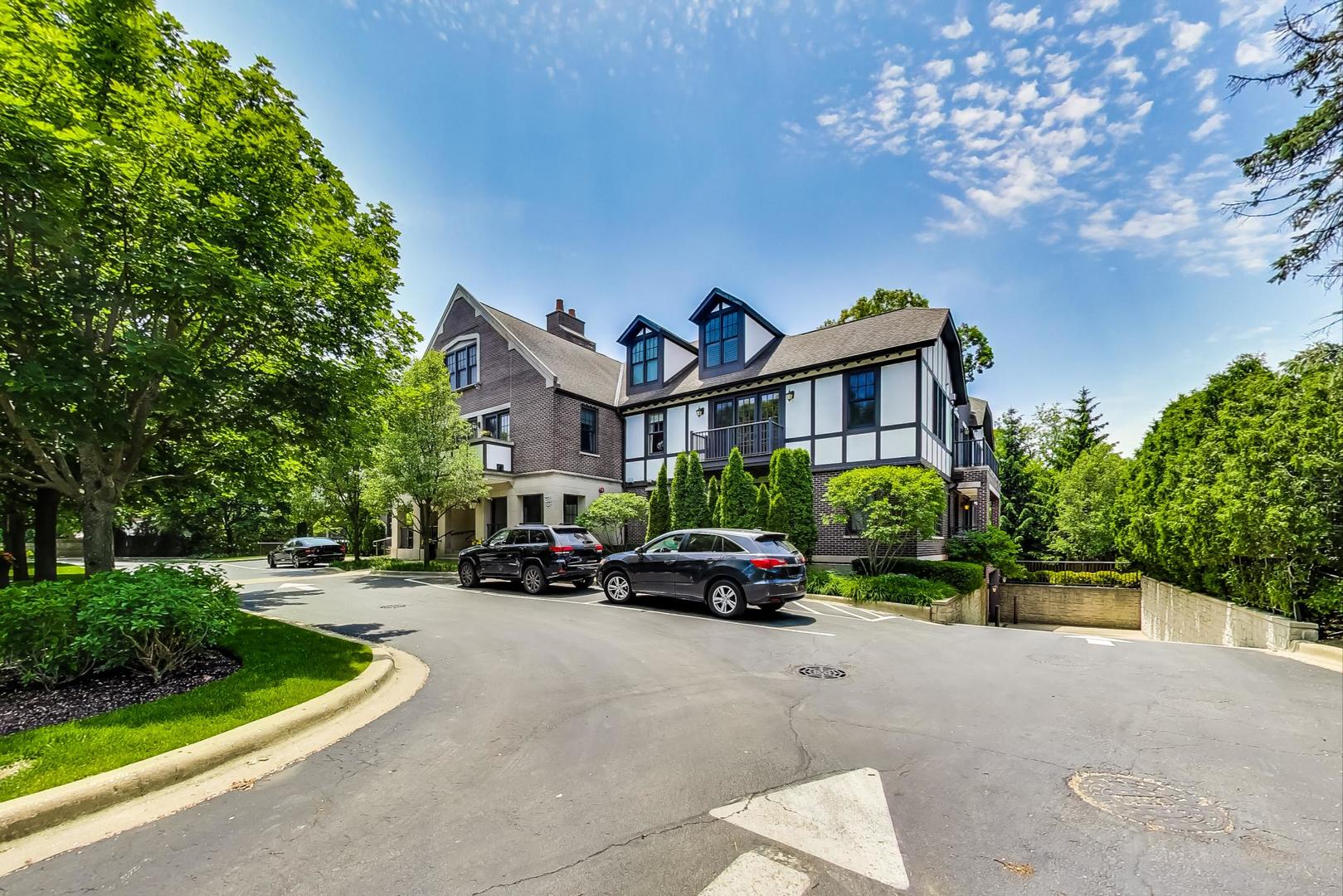 720 Green Bay Road, Unit 2D Winnetka, IL 60093 - Photo 40 of 41 a car parked in front of a brick house with large trees