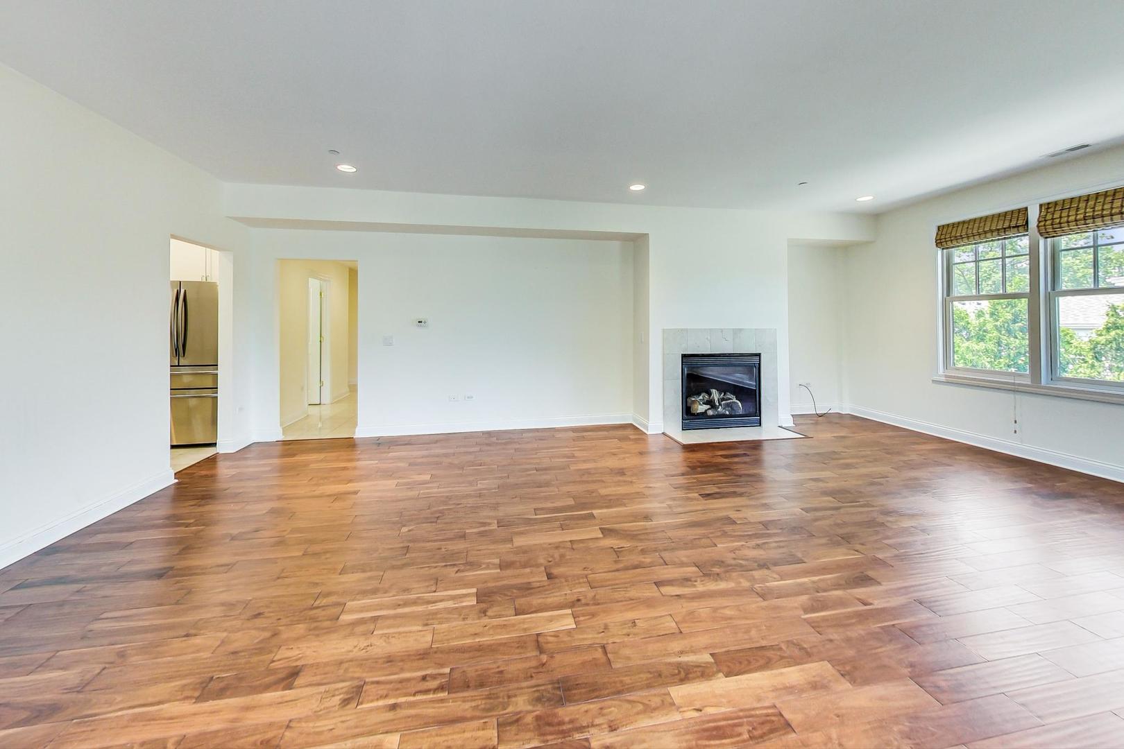 720 Green Bay Road, Unit 2D Winnetka, IL 60093 - Photo 5 of 41 an empty room with wooden floor and fireplace