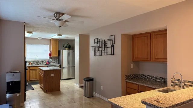 a kitchen with stainless steel appliances granite countertop a refrigerator and a stove top oven