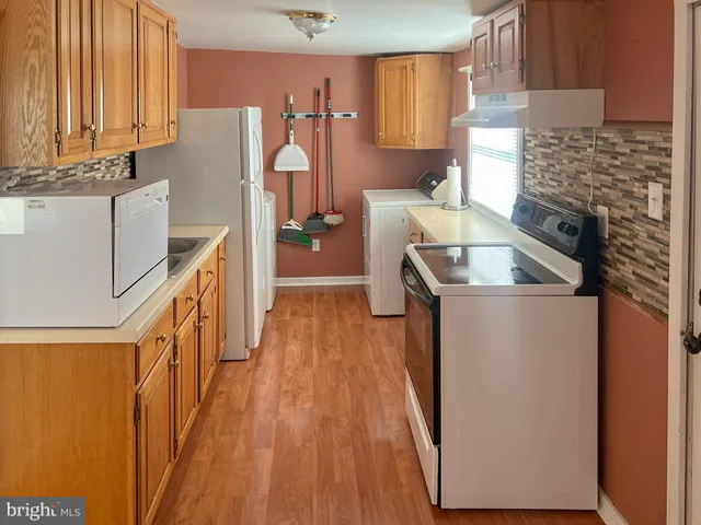 a kitchen with stainless steel appliances granite countertop a refrigerator a stove a sink and dishwasher