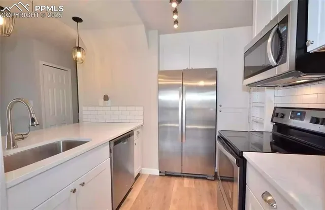 a kitchen with stainless steel appliances granite countertop a sink a stove and a refrigerator