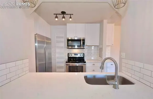 a kitchen with granite countertop a refrigerator and a sink