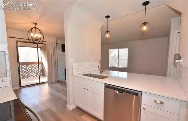 a kitchen that has a sink and a wooden floor