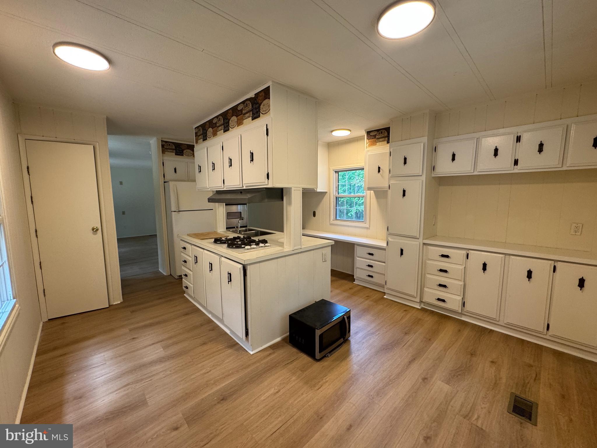 9216 Lawyers Road Spotsylvania, VA 22551 - Photo 6 of 19 a kitchen with cabinets a sink and wooden floor