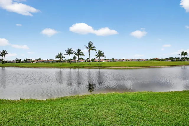 a view of a lake in front of house with yard and seating space