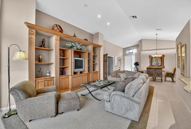 a living room with furniture kitchen view and a chandelier