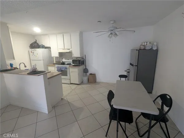 a kitchen with a table chairs appliances and cabinets