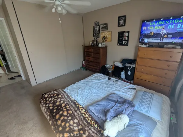 a bedroom with a bed and painting on the wall