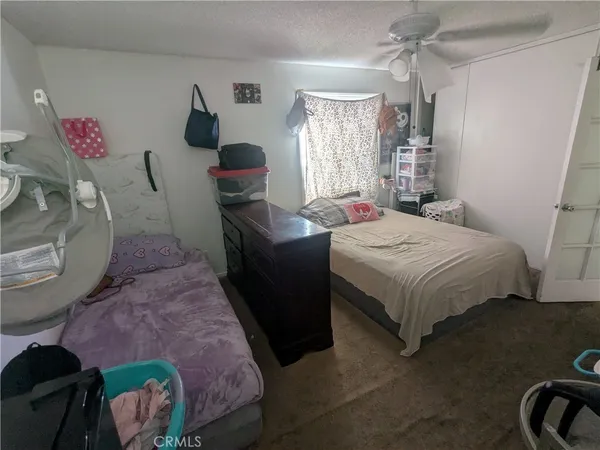 a bedroom with a bed mirror dresser and a window