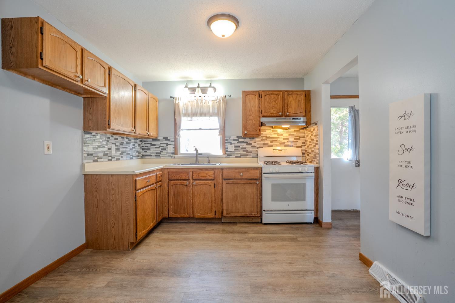 1834 Holly Road North Brunswick, NJ 08902 - Photo 12 of 26 a kitchen with stainless steel appliances a stove top oven and a refrigerator