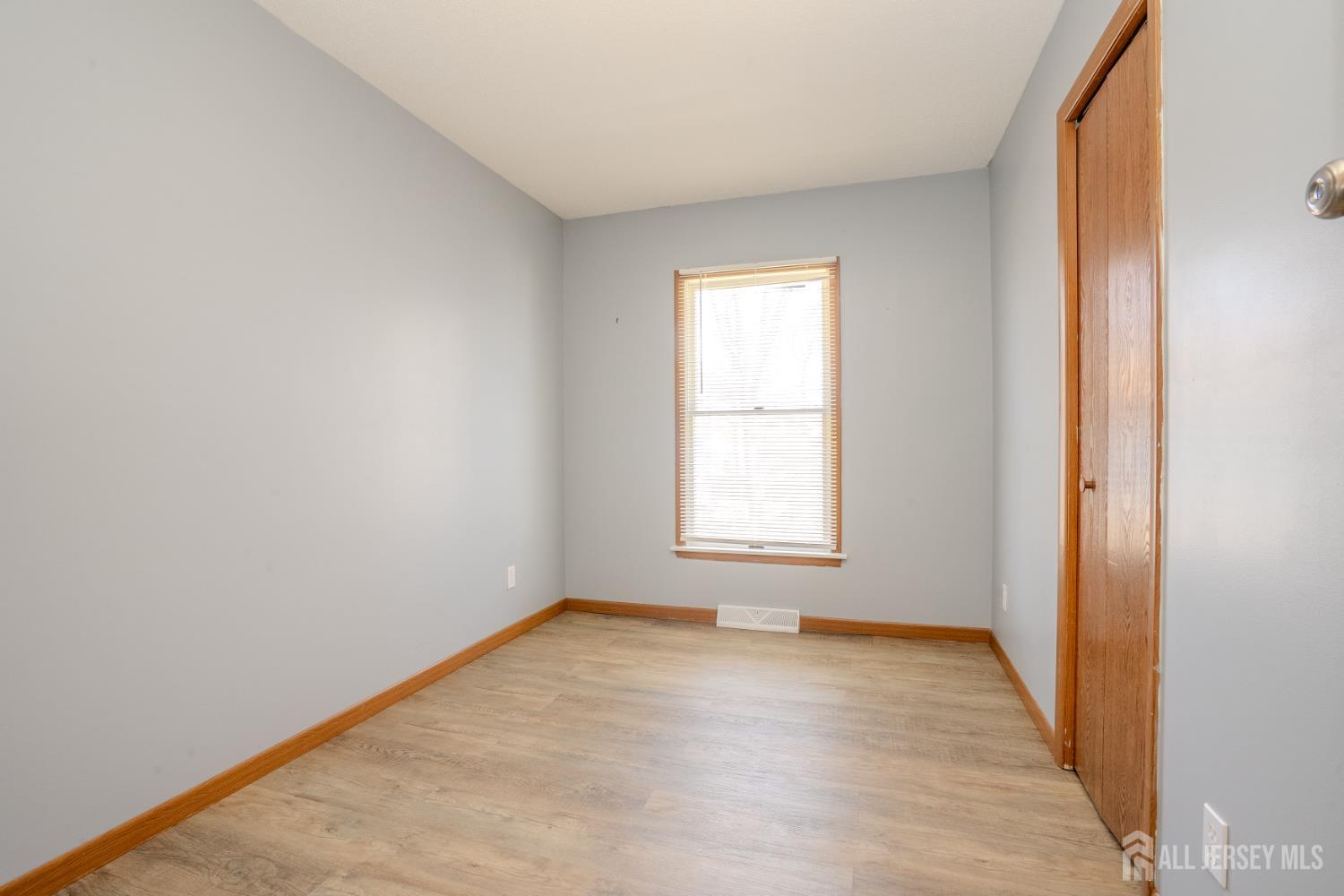 1834 Holly Road North Brunswick, NJ 08902 - Photo 13 of 26 an empty room with wooden floor and windows