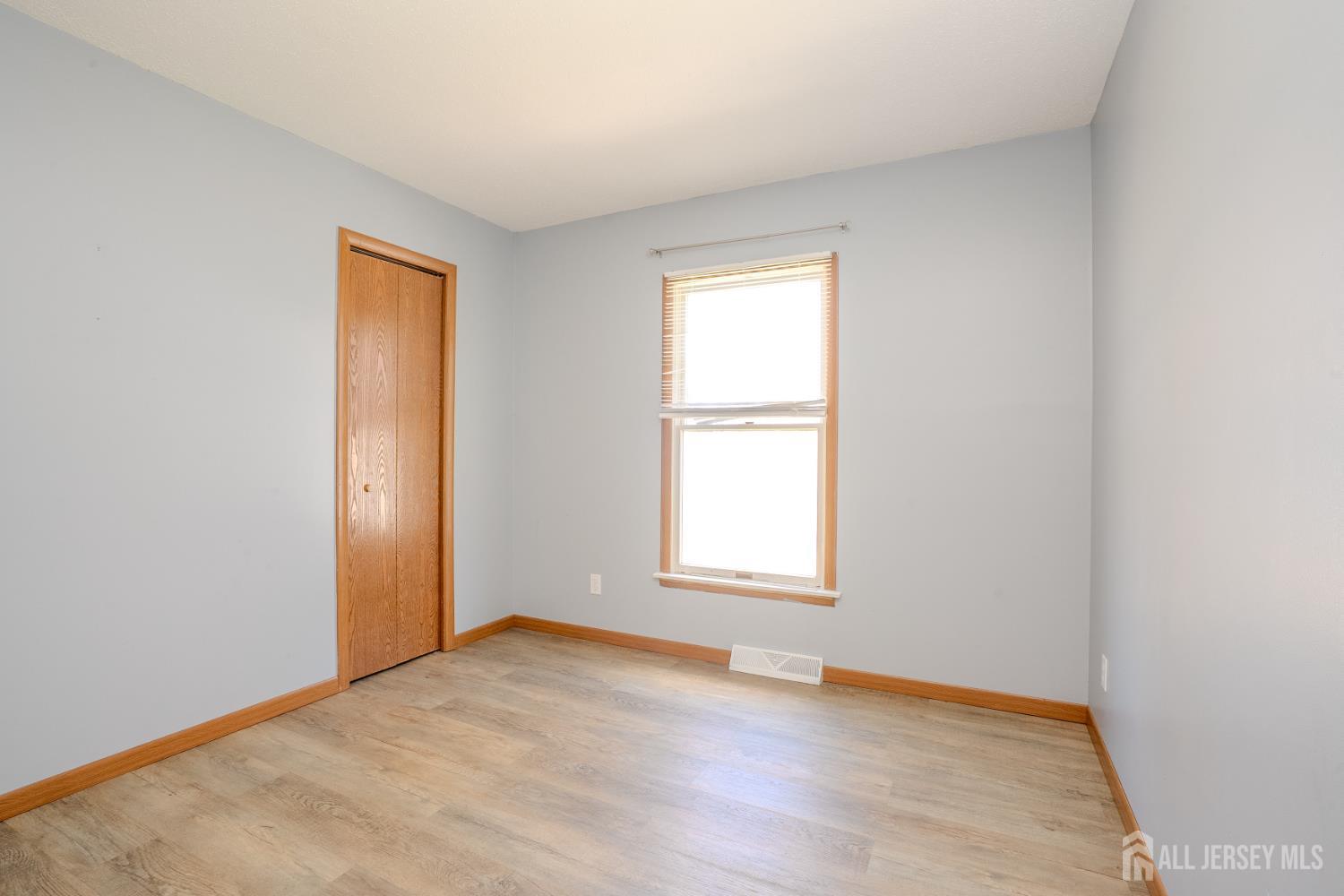 1834 Holly Road North Brunswick, NJ 08902 - Photo 14 of 26 an empty room with wooden floor and windows
