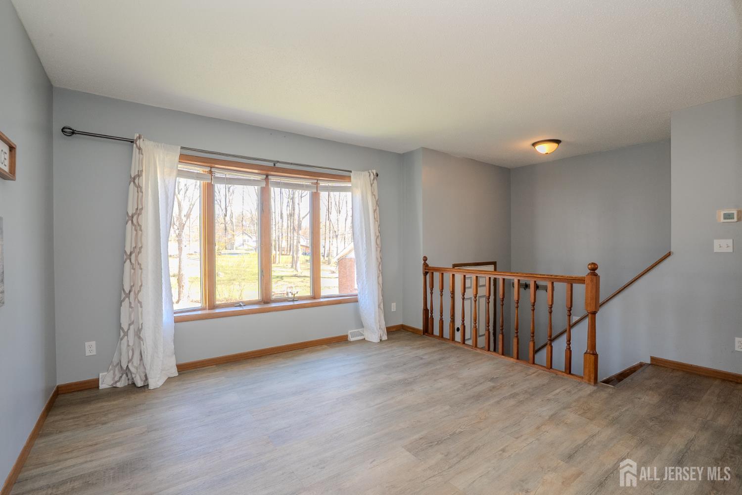 1834 Holly Road North Brunswick, NJ 08902 - Photo 4 of 26 a view of an empty room with wooden floor and a window