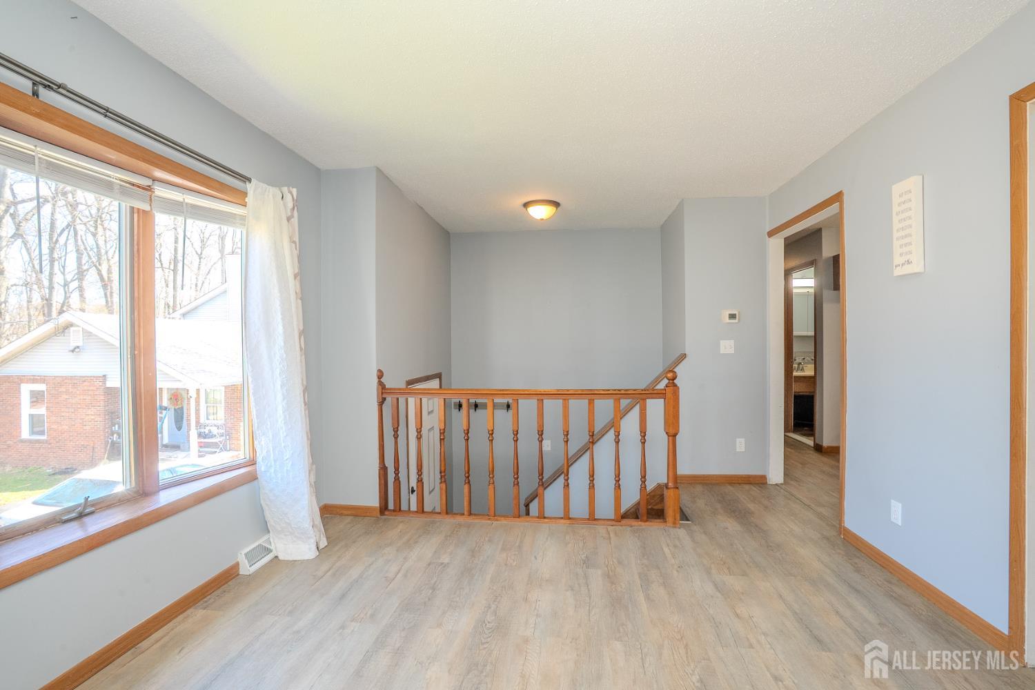 1834 Holly Road North Brunswick, NJ 08902 - Photo 5 of 26 a view of a hallway with wooden floor and windows