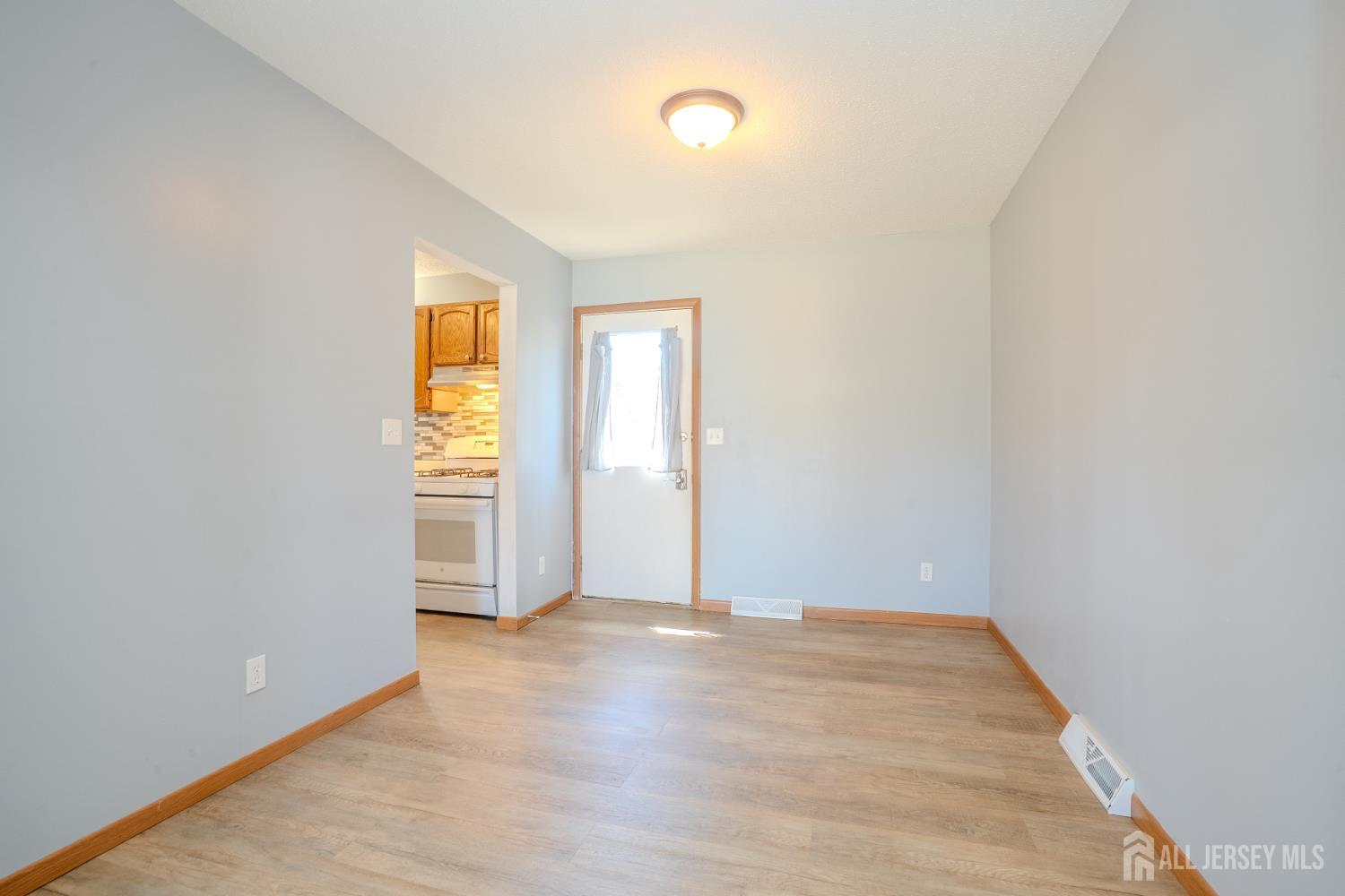 1834 Holly Road North Brunswick, NJ 08902 - Photo 7 of 26 an empty room with a window and wooden floor