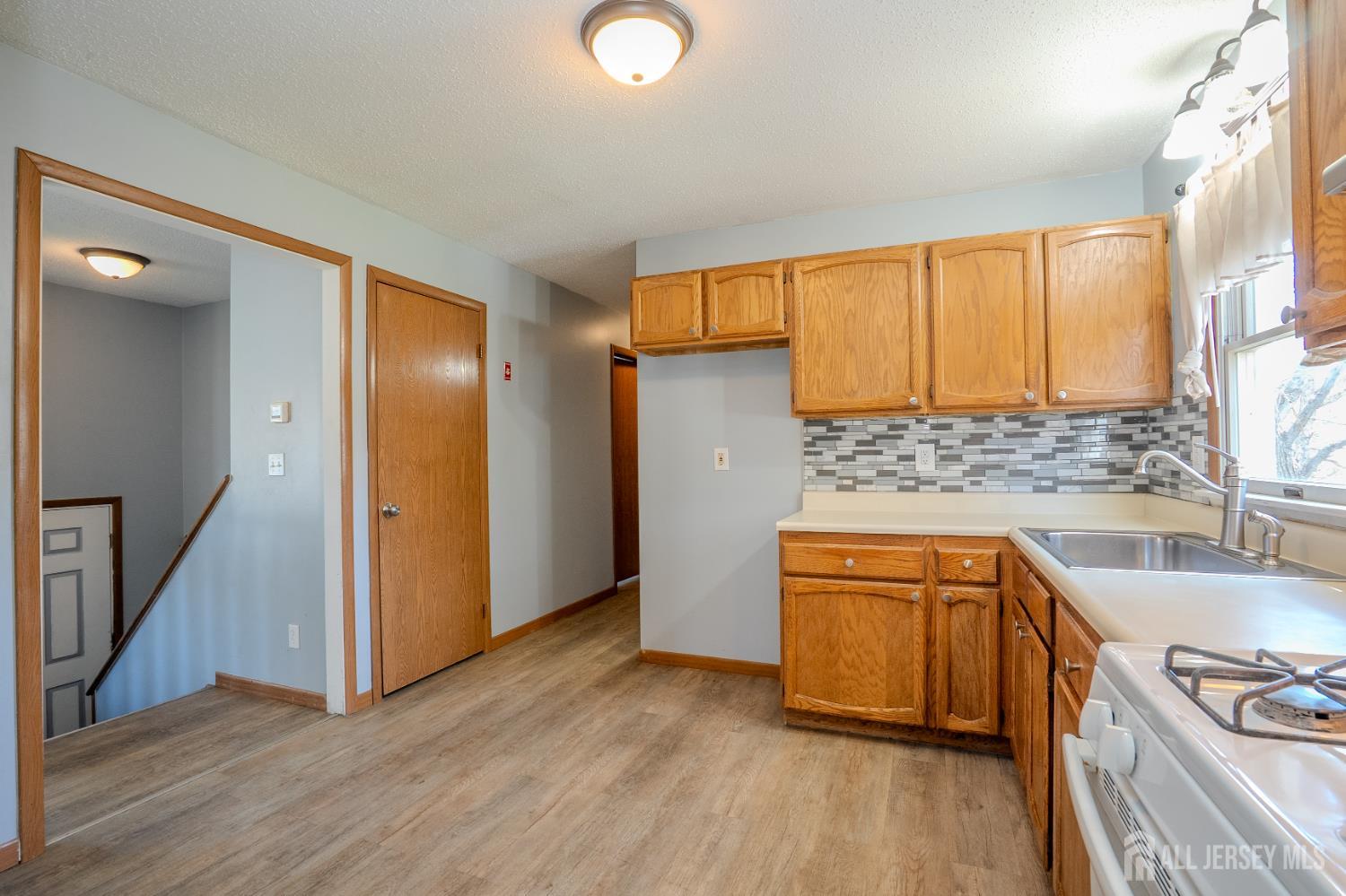 1834 Holly Road North Brunswick, NJ 08902 - Photo 9 of 26 a kitchen with granite countertop wooden floors and white stainless steel appliances