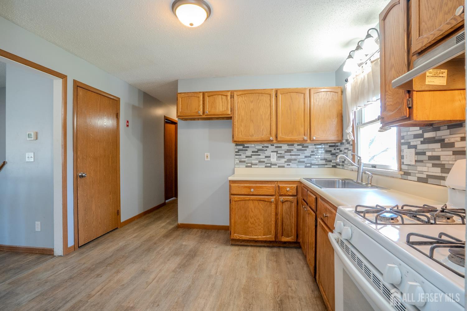 1834 Holly Road North Brunswick, NJ 08902 - Photo 10 of 26 a kitchen with stainless steel appliances granite countertop a sink stove and refrigerator