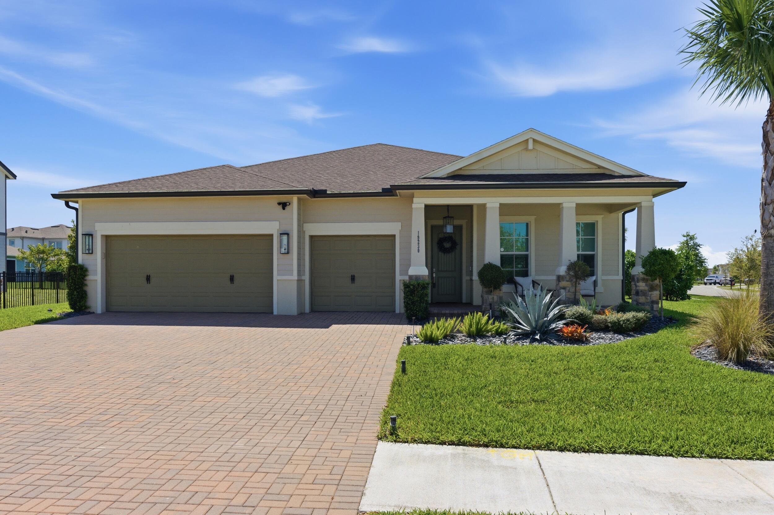 19230 Rolling Acres Road Loxahatchee, FL 33470 - Photo 2 of 58 a front view of a house with a yard and potted plants