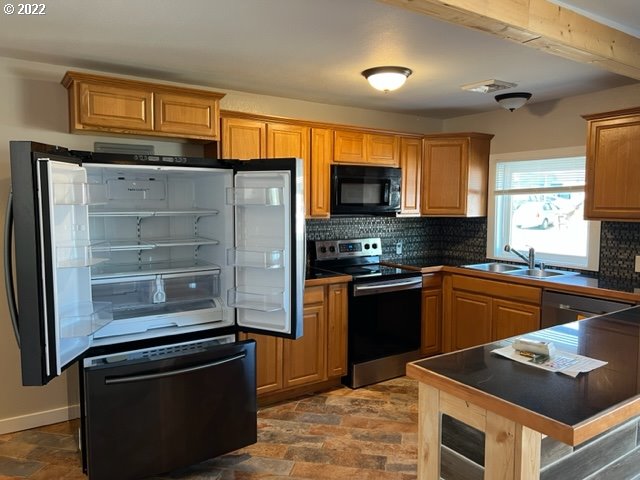 485 East 2nd Avenue Riddle, OR 97469 - Photo 9 of 25 a kitchen with granite countertop a refrigerator stove and sink