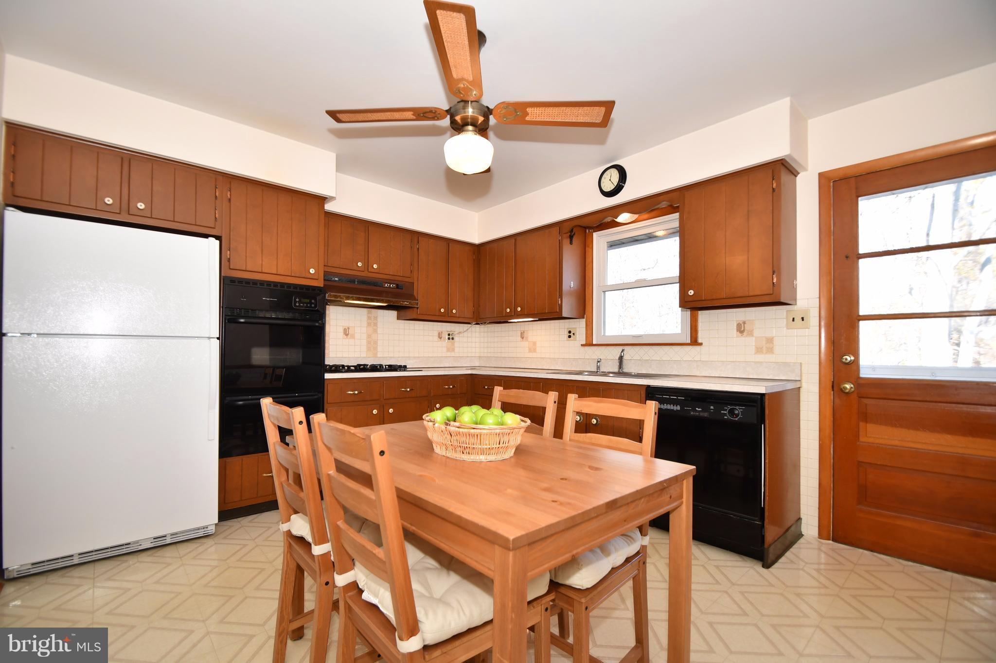 4314 Camellia Road Baltimore, MD 21236 - Photo 9 of 30 a kitchen with stainless steel appliances a stove a refrigerator and a refrigerator with wooden floor