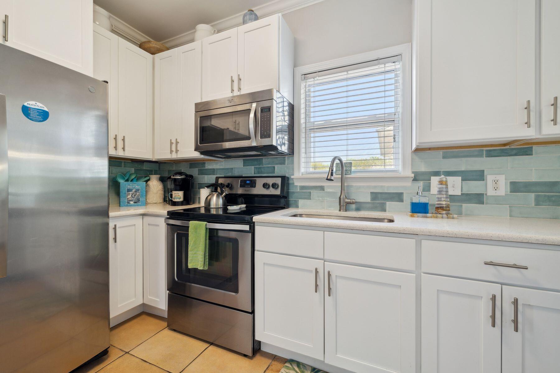 104 Emerald Dunes Circle Santa Rosa Beach, FL 32459 - Photo 18 of 53 a kitchen with white cabinets stainless steel appliances and sink