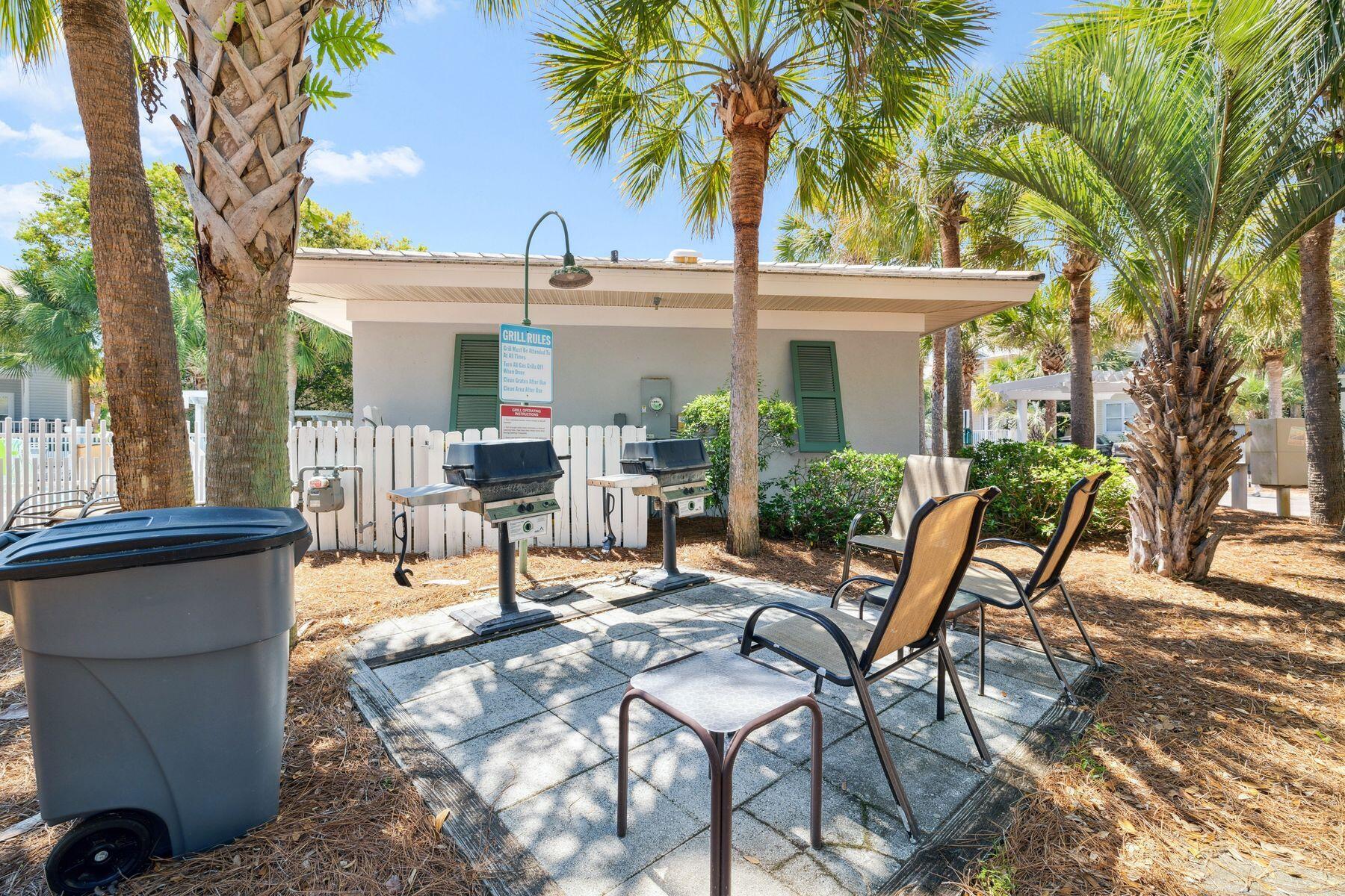 104 Emerald Dunes Circle Santa Rosa Beach, FL 32459 - Photo 41 of 53 a view of a patio with table and chairs potted plants and palm tree