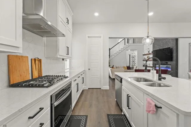 a kitchen with stainless steel appliances kitchen island granite countertop a sink stove and refrigerator