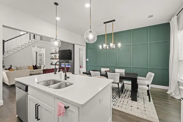 a kitchen with a table chairs and white cabinets