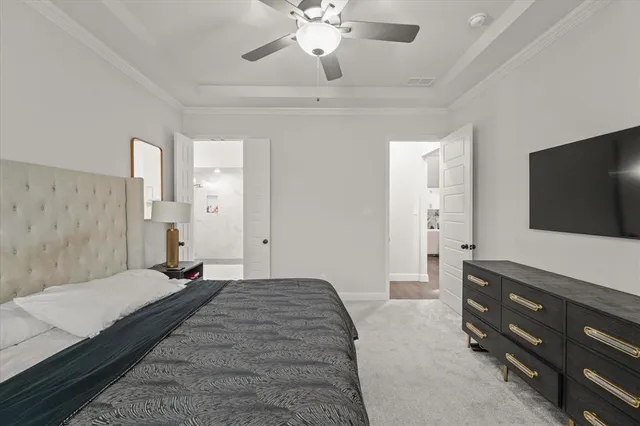 a spacious bedroom with a bed and a flat screen tv