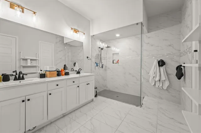 a bathroom with a double vanity sink mirror and shower