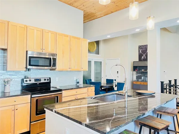 a kitchen with stainless steel appliances granite countertop a stove a sink and a microwave