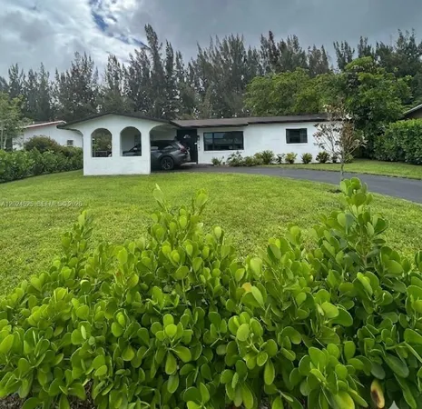 a view of a white house with a yard