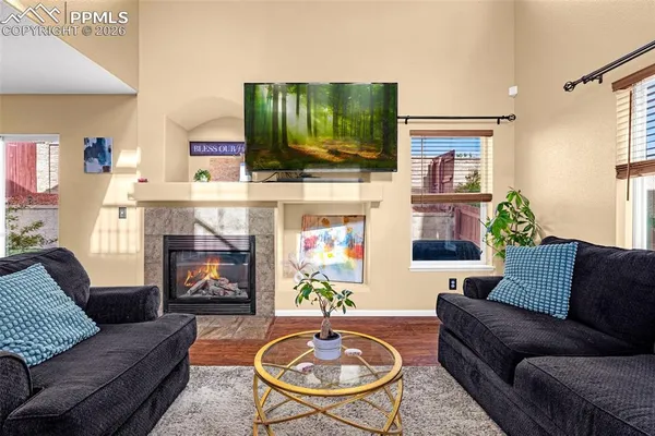 a living room with furniture a flat screen tv and a fireplace