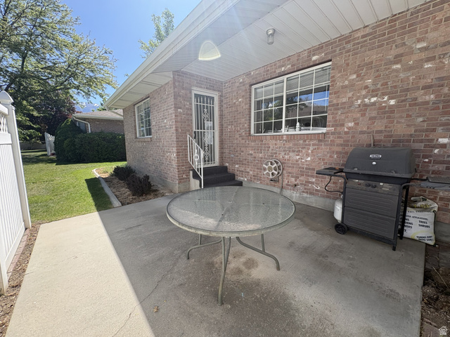 486 West 120 North Orem, UT 84057 - Photo 25 of 30 Brick exterior featuring a covered patio with a concrete surface