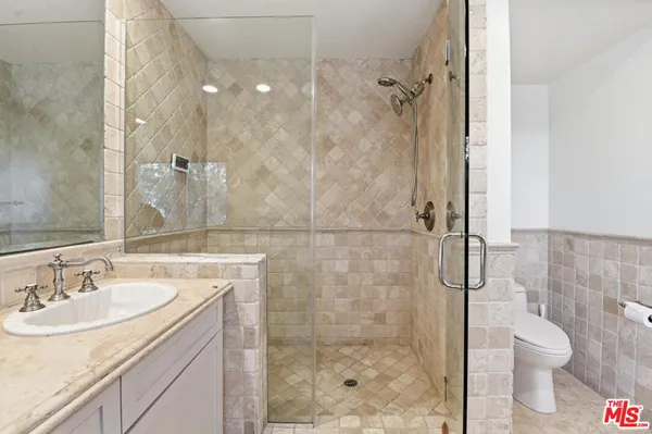 a bathroom with a double vanity sink toilet and shower