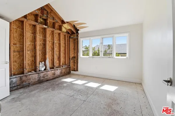 a view of a hallway with wooden floor and a bathroom