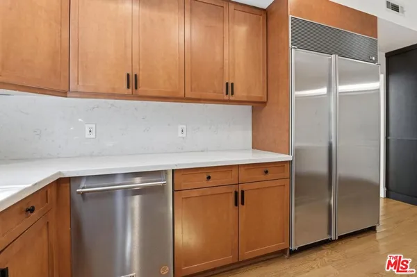 a kitchen with stainless steel appliances granite countertop white cabinets and a refrigerator