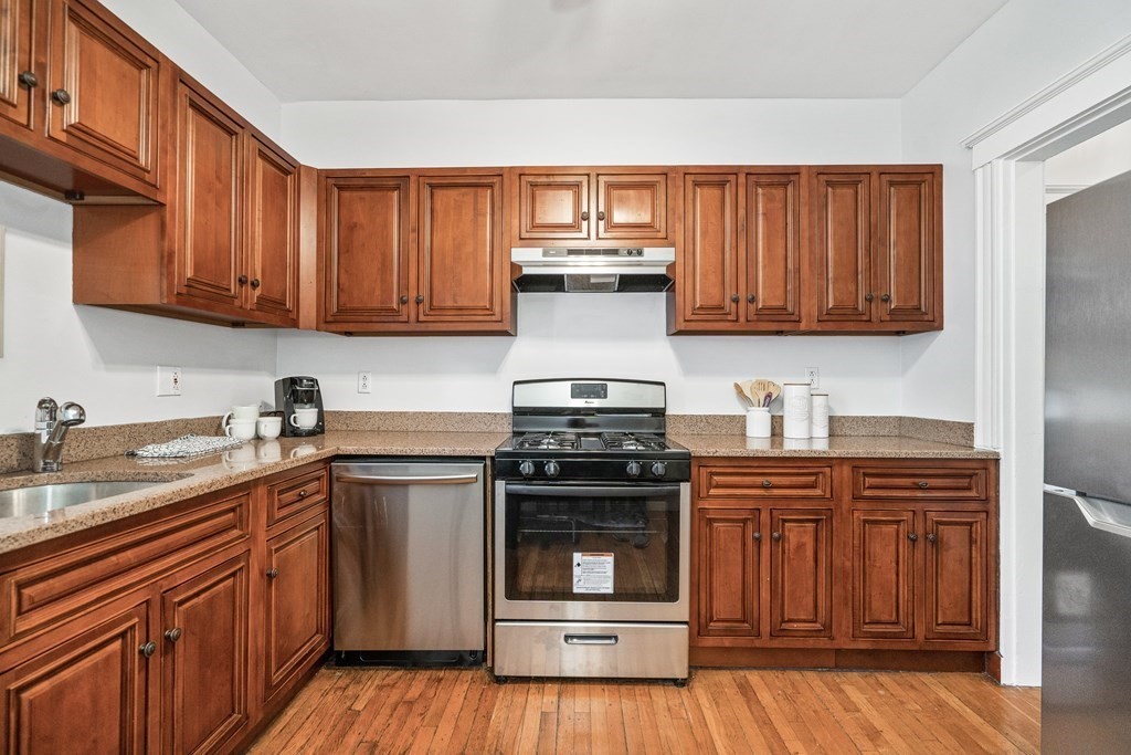 8 Kinross Road, Unit 4 Boston, MA 02135 - Photo 5 of 13 a kitchen with stainless steel appliances granite countertop a stove and cabinets
